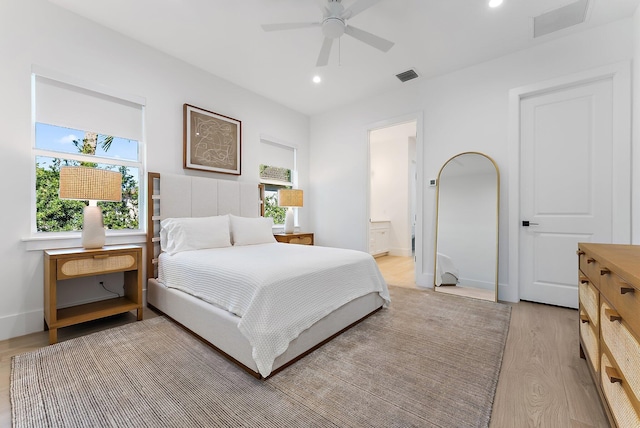 bedroom with connected bathroom, light hardwood / wood-style floors, and ceiling fan