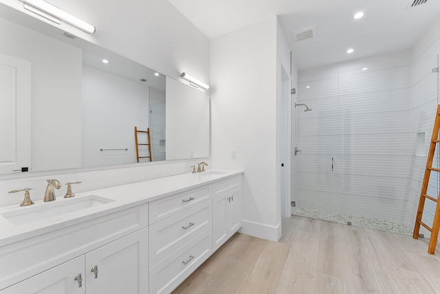 bathroom featuring hardwood / wood-style floors, vanity, and walk in shower