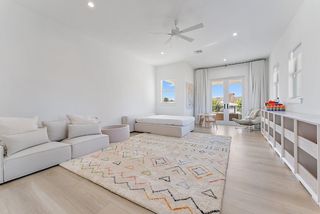 living room featuring ceiling fan, french doors, and light wood-type flooring