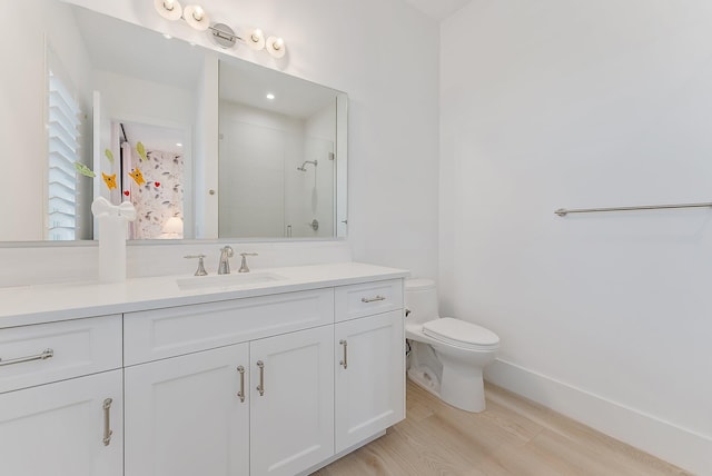 bathroom featuring hardwood / wood-style flooring, a shower with door, vanity, and toilet