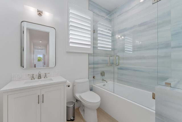 full bathroom featuring shower / bath combination with glass door, vanity, and toilet