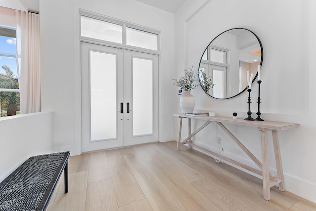 foyer entrance with french doors, light wood-type flooring, and plenty of natural light