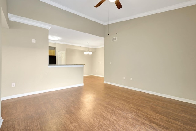 empty room featuring wood-type flooring, ceiling fan with notable chandelier, and ornamental molding