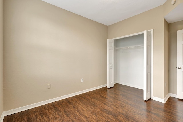 unfurnished bedroom with dark hardwood / wood-style floors and a closet