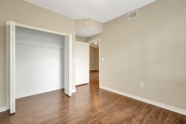 unfurnished bedroom with a closet and dark wood-type flooring