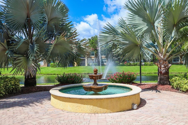 view of home's community featuring a lawn and a water view