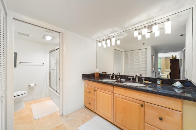 full bathroom featuring tile patterned floors, vanity, toilet, and shower / bath combination with glass door