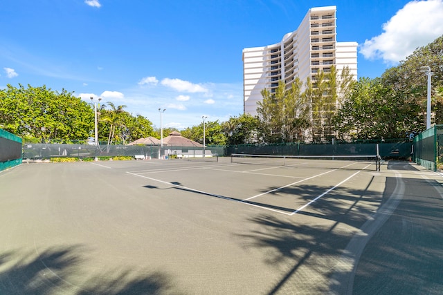 view of tennis court with basketball hoop