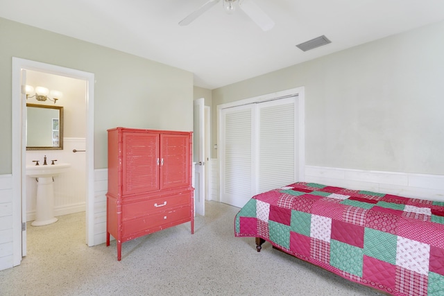 bedroom with ensuite bath, ceiling fan, and a closet