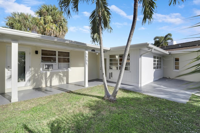 back of house featuring a patio area and a yard