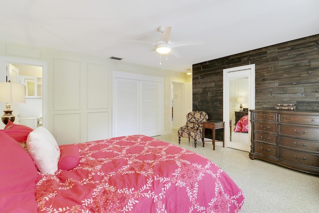 bedroom featuring ceiling fan and wood walls