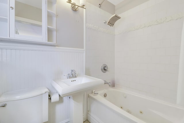 bathroom with toilet and tiled shower / bath