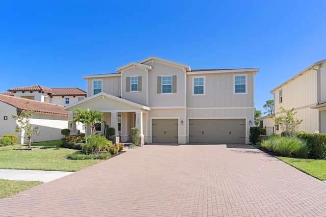 view of front of home with a garage, a front lawn, and covered porch