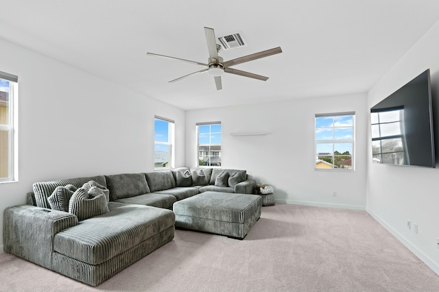 living room featuring ceiling fan, light colored carpet, and a healthy amount of sunlight