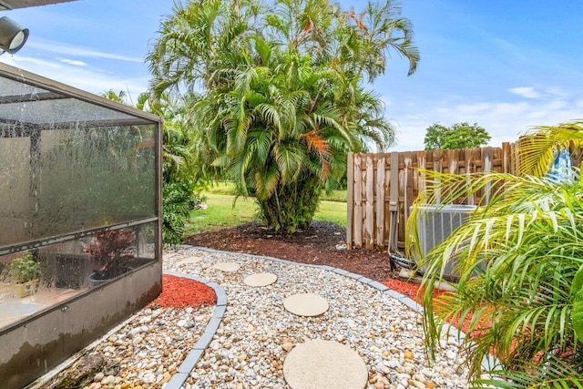 view of yard featuring cooling unit and a lanai