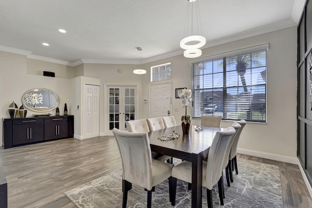 dining space with french doors, ornamental molding, and hardwood / wood-style floors