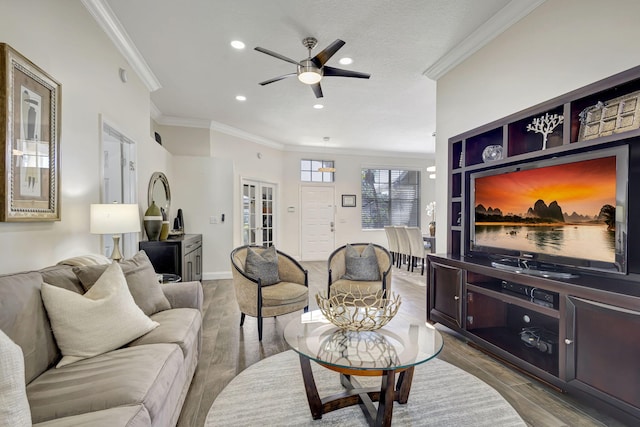 living room featuring hardwood / wood-style floors, ceiling fan, and crown molding