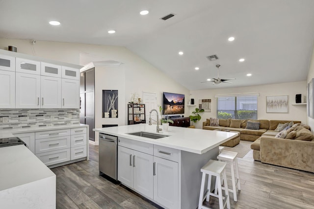 kitchen featuring a center island with sink, white cabinets, stainless steel dishwasher, and sink