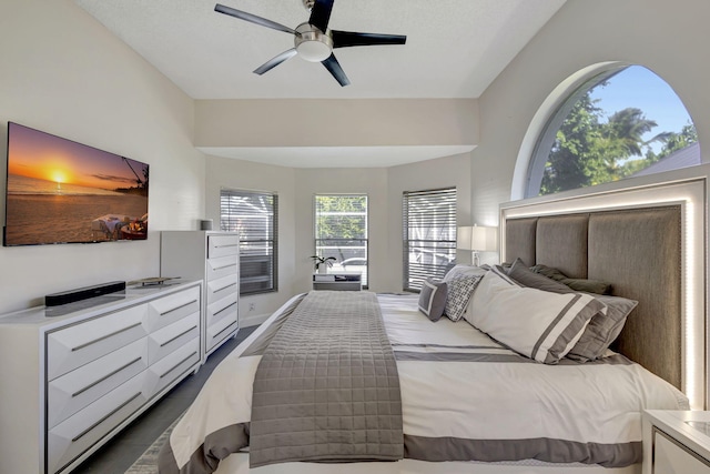 bedroom with a textured ceiling, ceiling fan, and vaulted ceiling