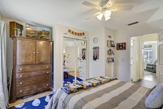 bedroom featuring a textured ceiling, a closet, ceiling fan, and light hardwood / wood-style floors