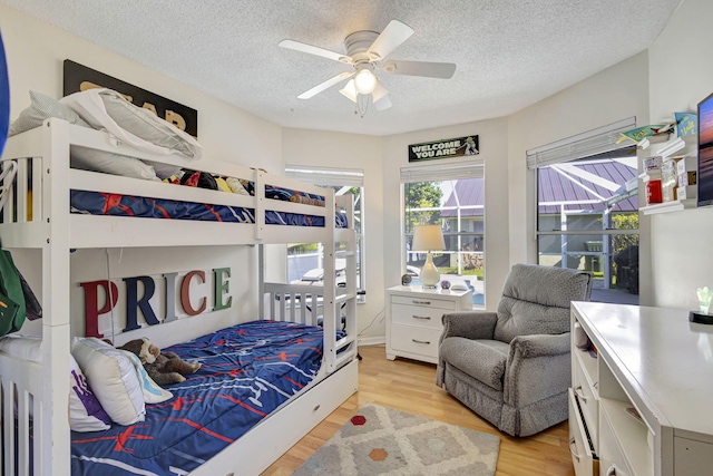 bedroom featuring a textured ceiling, light hardwood / wood-style flooring, and ceiling fan