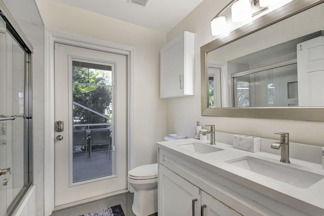 full bathroom featuring tile patterned flooring, vanity, toilet, and bath / shower combo with glass door