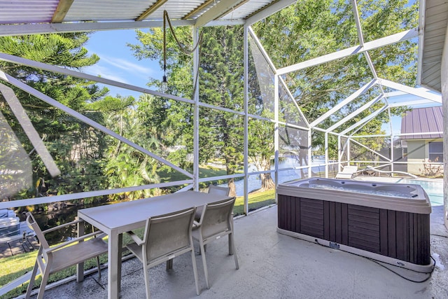 view of patio / terrace with a lanai, a water view, and a hot tub