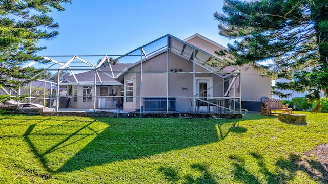 back of property featuring glass enclosure, a patio area, and a lawn