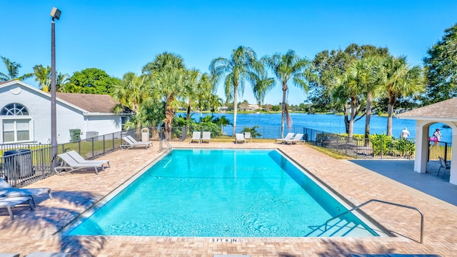 view of swimming pool with a water view and a patio