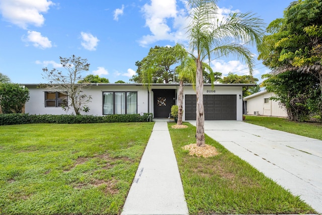 ranch-style home with a garage and a front lawn