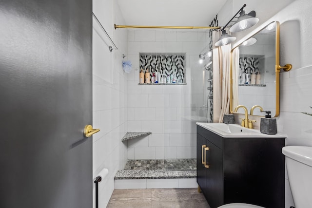 bathroom with vanity, a tile shower, and toilet