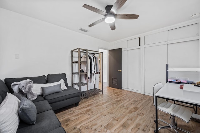 living room featuring ceiling fan and light hardwood / wood-style flooring