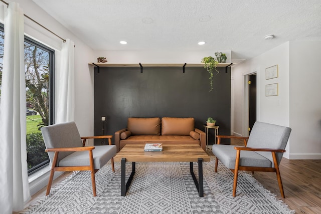 living area featuring light hardwood / wood-style flooring and a textured ceiling