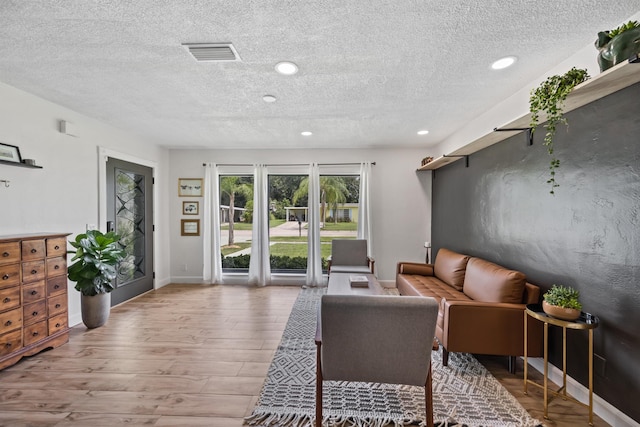 living room with hardwood / wood-style flooring and a textured ceiling