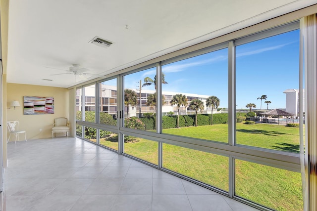 unfurnished sunroom featuring ceiling fan