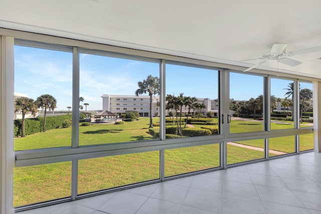 unfurnished sunroom with ceiling fan