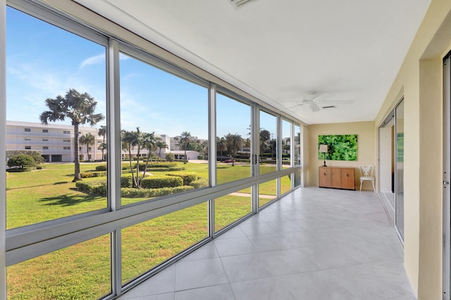 unfurnished sunroom with ceiling fan