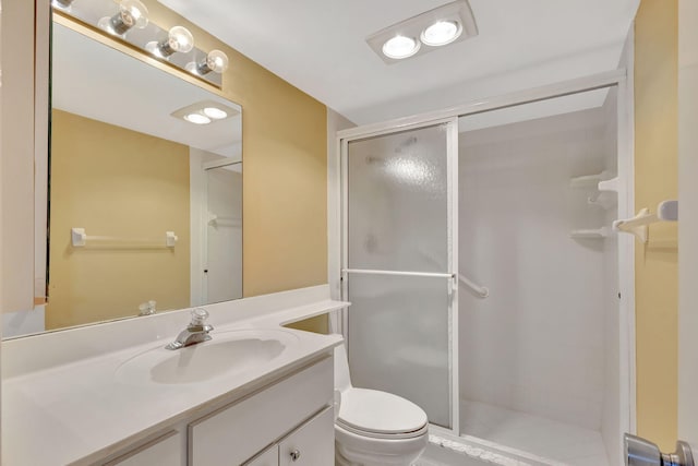 bathroom featuring vanity, toilet, and a shower with shower door