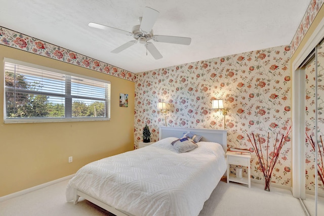 bedroom featuring ceiling fan, light carpet, and a closet