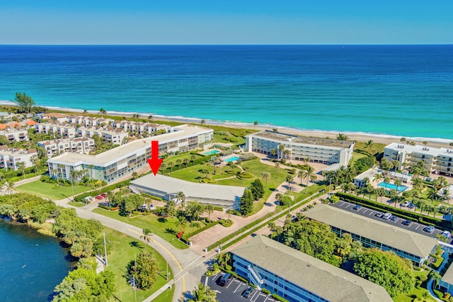 birds eye view of property featuring a water view and a beach view