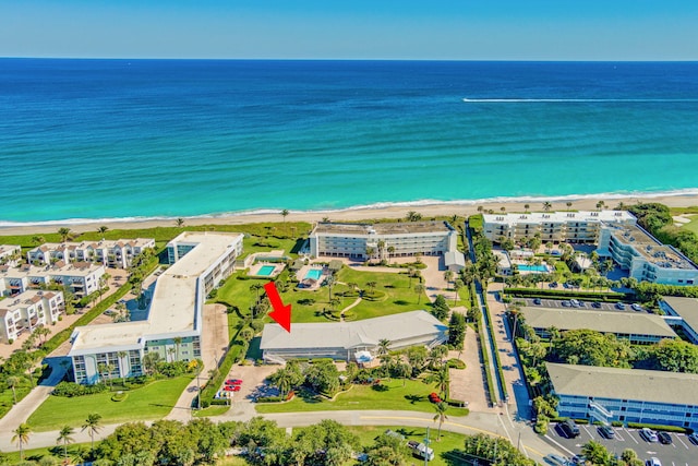 bird's eye view featuring a water view and a beach view