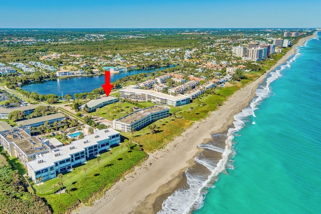 drone / aerial view featuring a water view and a beach view