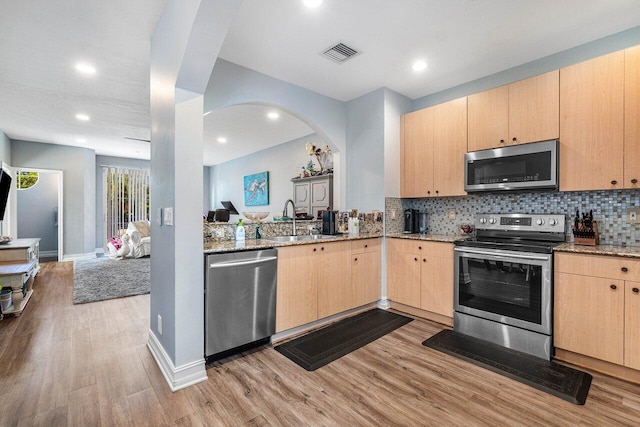 kitchen featuring light brown cabinets, sink, stainless steel appliances, and light hardwood / wood-style flooring