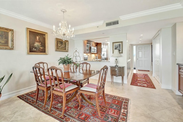 tiled dining room featuring sink, crown molding, and a chandelier