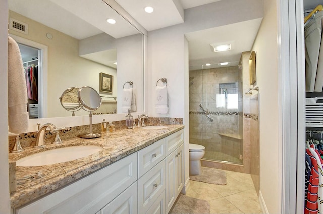 bathroom featuring tile patterned floors, vanity, toilet, and an enclosed shower