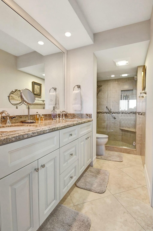 bathroom with tile patterned flooring, vanity, toilet, and a shower with shower door