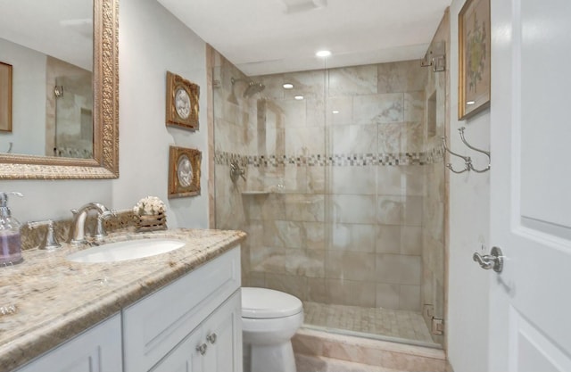 bathroom featuring vanity, toilet, and a shower with shower door