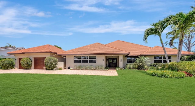 mediterranean / spanish house with a front yard and a garage