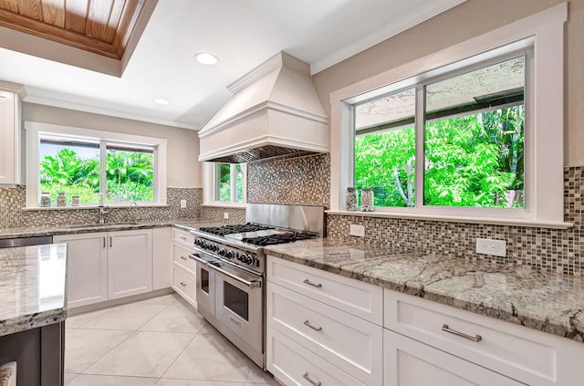 kitchen featuring white cabinetry, sink, range with two ovens, and custom range hood