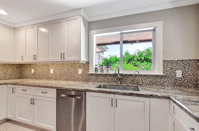 kitchen with white cabinets, backsplash, light stone countertops, and sink